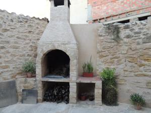 Valdealgorfa拉斯博得加斯德尔吉洛乡村民宿的一个带石墙和植物的户外烤箱
