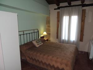 Valdealgorfa拉斯博得加斯德尔吉洛乡村民宿的一间卧室设有一张大床和一个窗户。