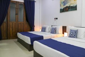 阿努拉德普勒Divine Villa的蓝色和白色的客房内的两张床