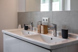 奥斯赛拜-屈隆斯博恩Hotel Rosenhof的白色的浴室设有两个盥洗盆和镜子