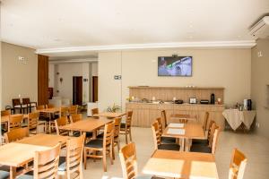 奥利韦拉Boa Vista Hotel的用餐室配有木桌和椅子