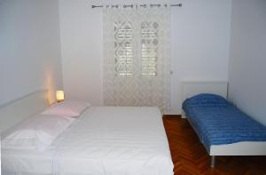 苏佩塔尔Rooms&Apartments Jerka的卧室配有白色的床和窗户。