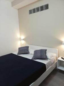 圣多米尼卡Cosmo Rooms a pochi passi da Tropea的一间卧室配有一张大床和两个枕头