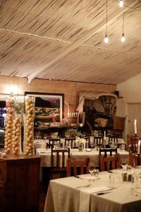 奥茨胡恩De Opstal Country Lodge的一间带白色桌椅的餐厅以及一间配有桌椅的房间