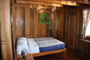 明多El Descanso的木墙客房内的小床