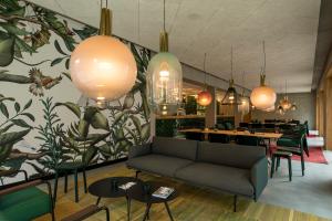 梅青根Kitz Boutique Hotel & Restaurant的餐厅配有沙发、桌子和吊灯