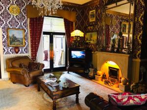 利物浦Castle Lodge Guest House 86-88 Sheil Rd L6 3AF的带沙发和壁炉的客厅