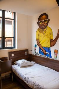 图卢兹帕斯特尔酒店的卧室,墙上挂着一幅带太阳镜的男人的照片