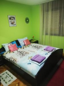 尼什Apartment Bojke的绿色客房内的一张床位,上面有毛巾