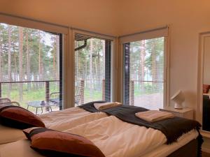 库斯塔维Kustavin Lootholma的一间卧室设有一张床和两个大窗户