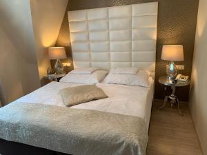 杰尔Hunyadi的一间卧室配有一张带两盏灯的大型白色床。