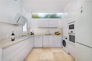 马斯帕洛马斯Villa Deluxe Suites Maspalomas的白色的厨房配有水槽和洗碗机