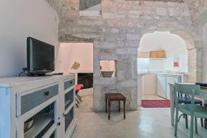 奥斯图尼Casa Le Mura的带电视的客厅和厨房。