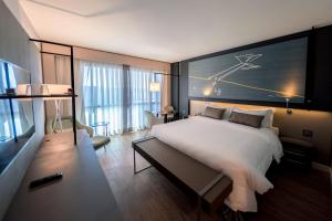 巴西利亚巴西利亚阿尔沃拉达皇家郁金香酒店的酒店客房设有一张大床和一张书桌。