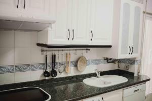 特鲁希略APARTAMENTO FRANCISCO PIZARRO的白色的厨房设有水槽和台面