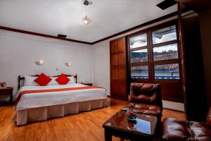 库斯科Royal Inka II的一间卧室配有一张带红色枕头的床和一张沙发