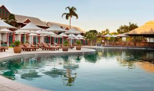 布鲁姆凯布尔海滩俱乐部度假村及水疗中心酒店的度假村内带椅子和遮阳伞的游泳池