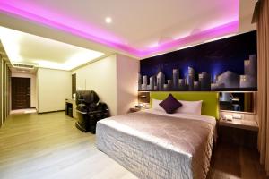 台北嘉年华汽车旅馆的一间卧室配有一张紫色照明床