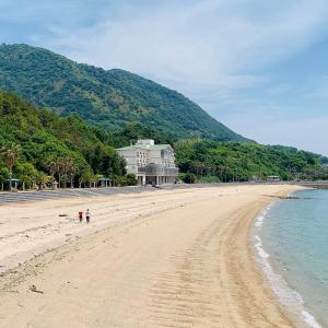 EtajimaUminos Spa & Resort的享有海滩美景,设有位于后面的房子