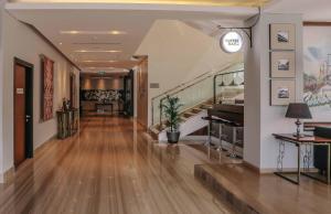 泗水泗水高级商务酒店的大楼内带木地板和楼梯的走廊