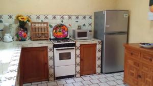 特基斯基亚潘VILLA COLONIAL的厨房配有炉灶和冰箱。