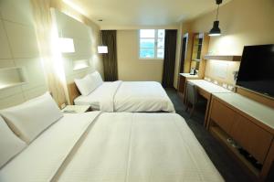 花莲市康桥商旅-花莲站前馆的酒店客房设有两张床和一台平面电视。