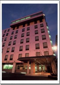 泉佐野康库太阳丰酒店的一座大型粉红色建筑,有很多窗户