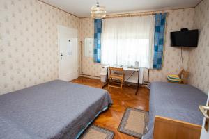 波斯托伊纳ANA.k宾馆的一间卧室设有两张床、一张桌子和一个窗口。