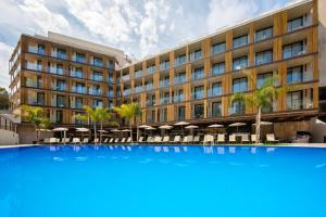 萨洛Golden Costa Salou - Adults Only 4* Sup的一座大型建筑,前面有一个大型蓝色游泳池