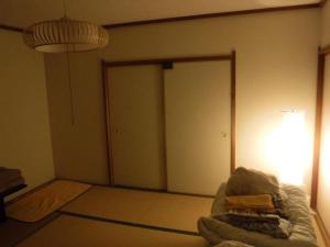 广岛广岛日式旅馆的一间设有床、门和灯的房间