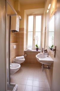 阿拉西奥Residence Conchiglia Aparthotel的一间带两个盥洗盆、卫生间和窗户的浴室