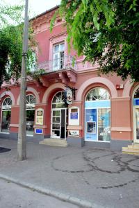 考洛乔Piros Arany Panzió Kalocsa的街道边的粉红色建筑