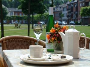 利奥波德斯布尔格太子港皇家酒店的一张桌子,上面放着一杯葡萄酒和一瓶葡萄酒