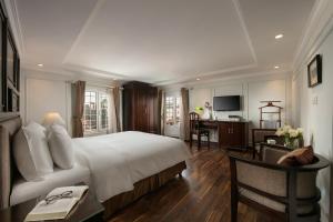 河内Hong Ngoc Dynastie Boutique Hotel & Spa的酒店客房设有一张大床和一张书桌。