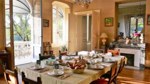 VallenayB&B Château de Preuil的用餐室配有长桌、椅子和壁炉