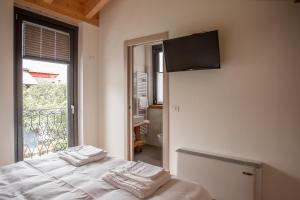 Villa di Tiranoforesteria stazzona的卧室配有一张壁挂式平面电视的床。