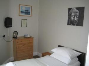 威姆斯洛The Kings Arms的一间卧室配有一张床、梳妆台和一张照片