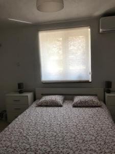 塞尼RougeMARIN apartments的一间卧室配有带两个枕头的床和窗户
