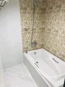 马尼拉城市旅行者酒店的浴室配有白色浴缸和淋浴。