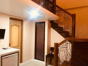 马尼拉城市旅行者酒店的一间设有螺旋楼梯和楼梯的房间
