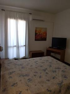 莱波拉诺Villa Giada-8 appartamenti的一间卧室配有一张大床和电视