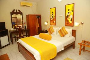 拉维尼亚山Ranveli Beach Resort的一间卧室配有一张黄色毯子床