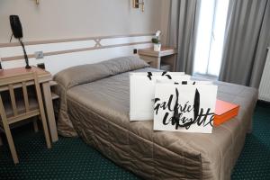 巴黎阿尔纳酒店的酒店客房,配有一张带标志的床
