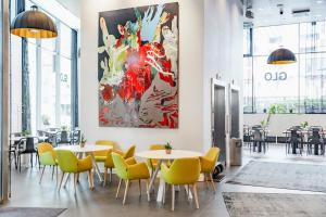 埃斯波GLO Hotel Sello的餐厅设有桌椅,墙上挂有绘画作品