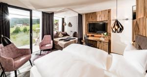 马兰扎Alpine Spa Resort Sonnenberg的酒店客房设有一张床和一个大窗户