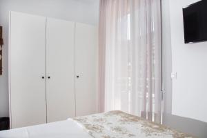 依克希亚Elenis Philoxenia的一间卧室配有床和带窗帘的窗户