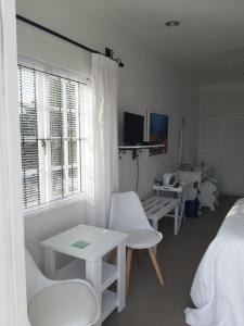 普利登堡湾弗拉马雷尔住宿加早餐旅馆的卧室配有白色家具、床和窗户。