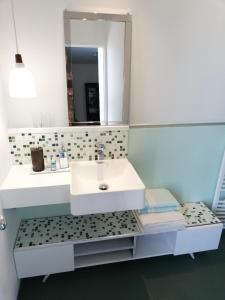 克莱蒙费朗Monts Dôme的浴室设有白色水槽和镜子