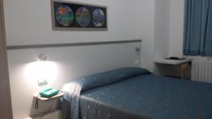 阿拉西奥Hotel San Giorgio的一间卧室配有一张带蓝色床罩和灯的床。