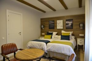 El CuervoLa casita de El Cuervo的一间卧室配有两张带黄色和蓝色枕头的床